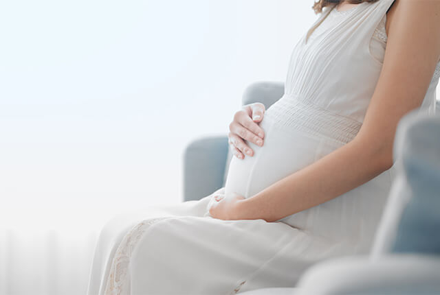 お腹に手を当てている妊婦さん